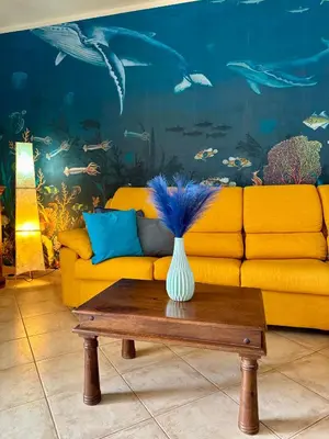 a living room with a yellow couch and a vase on a table at Tropical Mar Profundo in Santa Maria