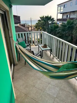 a hammock on a balcony with a view of the ocean at Estrella Do Mar Santa Maria in Santa Maria