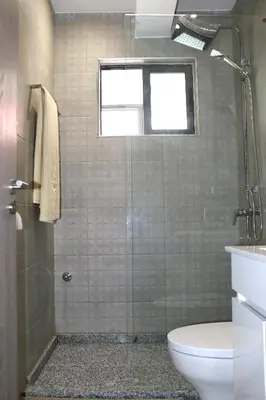 a bathroom with a shower and a toilet and a window at Alto in Mindelo