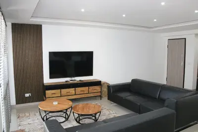 a living room with a black couch and a flat screen tv at Alto in Mindelo