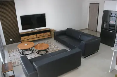 a living room with a black couch and a tv at Alto in Mindelo