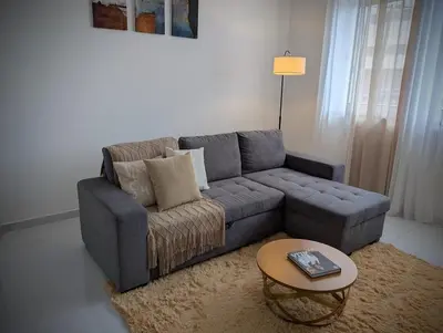 a living room with a couch and a table at Modern and Stylish 1BR Apt - Cidadela - Ground Floor in Praia