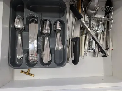 a drawer filled with silver utensils in a drawer at Modern and Stylish 1BR Apt - Cidadela - Ground Floor in Praia