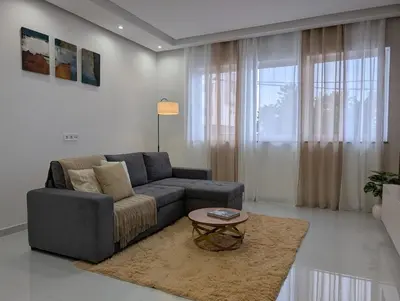 a living room with a couch and a table at Modern and Stylish 1BR Apt - Cidadela - Ground Floor in Praia