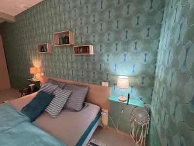 a bedroom with a bed and a green wall at Casa Paradise in Santa Maria