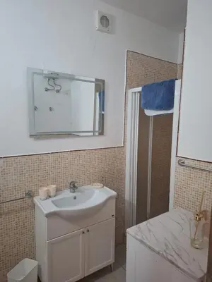 a bathroom with a sink and a mirror and a shower at Djadsal Moradias - Near the ocean in Santa Maria