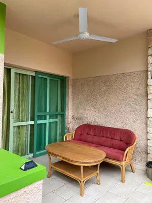 a red couch sitting on a patio with a table at Djadsal Moradias - Near the ocean in Santa Maria