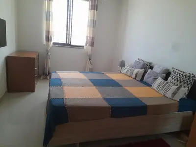 a bedroom with a bed with a checkered blanket on it at Conforto in Praia