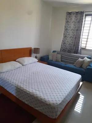 a bedroom with a bed and a blue couch at Conforto in Praia