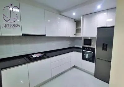 a white kitchen with white cabinets and a refrigerator at Aconchego da Bety in Praia