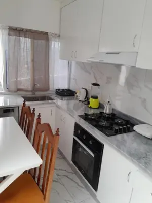 a kitchen with a stove and a table with chairs at Repousando no terraço in Ribeira Grande