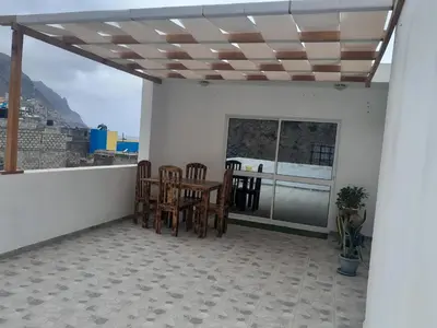 a patio with a table and chairs on a balcony at Repousando no terraço in Ribeira Grande