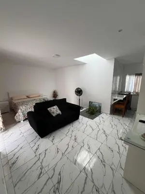 a living room with a black couch and a bed at Repousando no terraço in Ribeira Grande