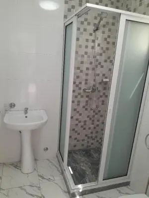 a bathroom with a shower and a toilet and a sink at Repousando no terraço in Ribeira Grande