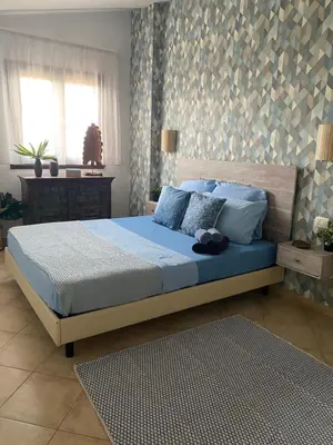 a bedroom with a bed with blue sheets and pillows at Tropical Oceano in Santa Maria