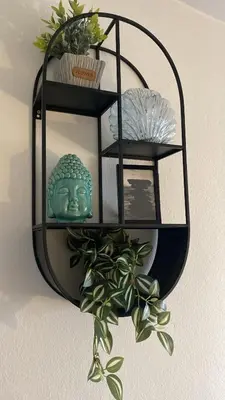a black mirror hanging on a wall with a plant at Tropical Oceano in Santa Maria
