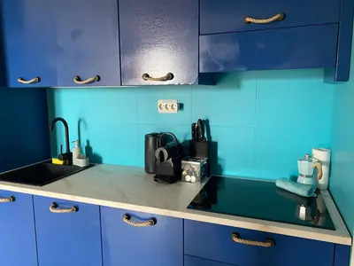 a blue kitchen with a sink and blue cabinets at Tropical Oceano in Santa Maria