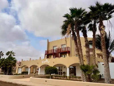 a building with palm trees in front of it at Tropical Oceano in Santa Maria