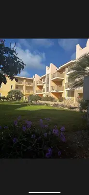 a large building with purple flowers in front of it at Tropical Oceano in Santa Maria