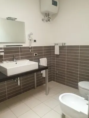 a bathroom with a sink and a toilet and a mirror at Aparthotel Por do Sol in Sal Rei