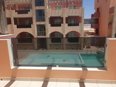 a swimming pool in front of a building at Aparthotel Por do Sol in Sal Rei