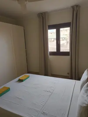 a bedroom with a white bed with a window at Marialva Tropical T1 in Santa Maria
