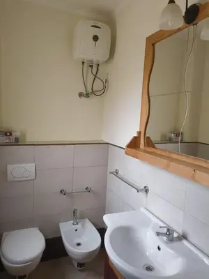 a bathroom with a sink and a toilet and a mirror at Marialva Tropical T1 in Santa Maria