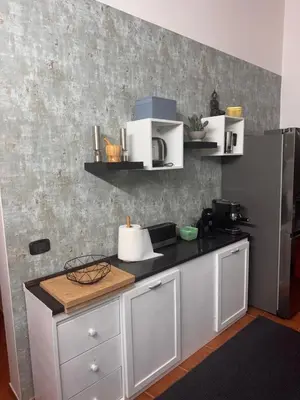 a kitchen with white cabinets and a refrigerator at Casa Anzso Ocean view Porto Antigo I in Santa Maria