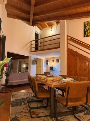 a dining room with a wooden table and chairs at Casa Anzso Ocean view Porto Antigo I in Santa Maria