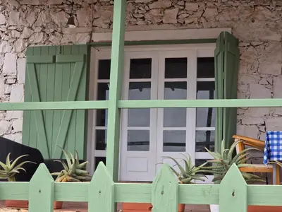 a house with a green door and a fence at Bougainvillea Villa in Cidade Velha