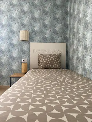 a bedroom with a bed with a gray and white patterned wall at Tropical Anzso in Santa Maria