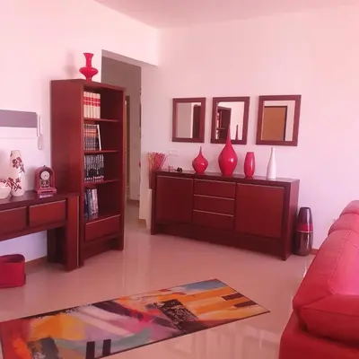 a living room with red vases and a book shelf at 3-bedroom Apartment Praia Santiago in Praia