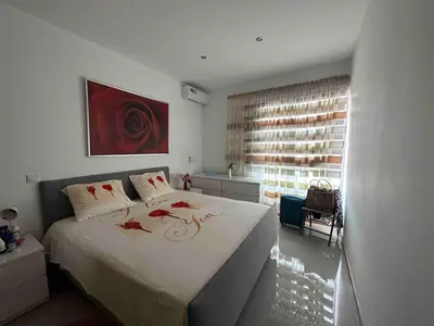 a bedroom with a large bed with red flowers on it at 3-bedroom Apartment Praia Santiago in Praia