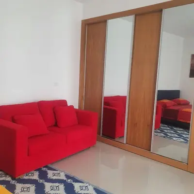 a living room with a red couch and a mirror at 3-bedroom Apartment Praia Santiago in Praia