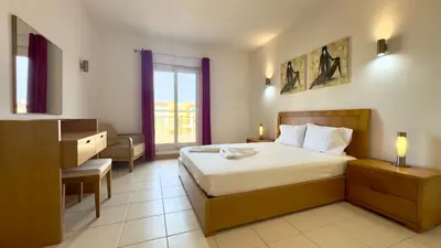 a bedroom with a bed and a desk and a window at Exclusive 3-Bedroom Apartment Vila Verde Resort in Santa Maria