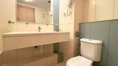 a bathroom with a toilet and a sink and a mirror at Exclusive 3-Bedroom Apartment Vila Verde Resort in Santa Maria