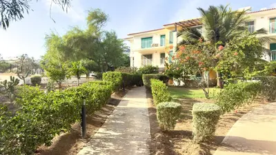 a garden in front of a house with bushes at Exclusive 3-Bedroom Apartment Vila Verde Resort in Santa Maria