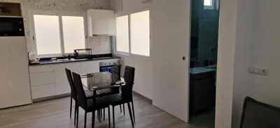 a kitchen with black chairs and white cabinets at Ines Studio T0 - Inforsal in Espargos