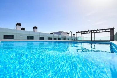 a swimming pool with blue water in front of a building at Terra Boa beach apartment Sal Cabo Verde in Santa Maria