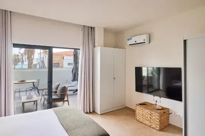 a bedroom with a bed and a flat screen tv at Terra Boa beach apartment Sal Cabo Verde in Santa Maria