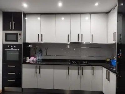a kitchen with white cabinets and a black counter top at Sofia Évora Spínola in Cova Figueira