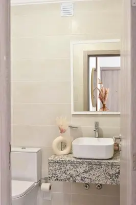 a bathroom with a sink and a toilet and a mirror at Gorgeous 3-bdr apt - 1-min laginha beach - LCGR in Mindelo