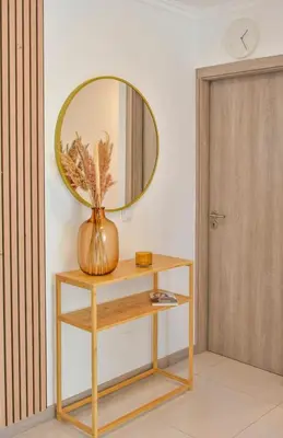 a vase on a table with a mirror on a wall at Gorgeous 3-bdr apt - 1-min laginha beach - LCGR in Mindelo