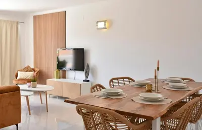 a dining room with a wooden table and chairs at Gorgeous 3-bdr apt - 1-min laginha beach - LCGR in Mindelo