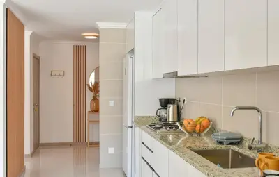 a kitchen with white cabinets and a counter top at Gorgeous 3-bdr apt - 1-min laginha beach - LCGR in Mindelo