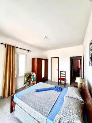a bedroom with two beds and a chair at Casa BB&Djassi - Apartment T3 in Ponta do Sol