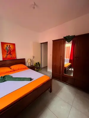 a bedroom with a large bed with an orange comforter at Casa BB&Djassi - Apartment T3 in Ponta do Sol
