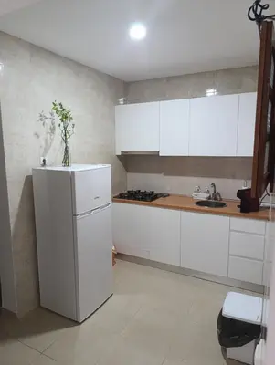 a kitchen with white cabinets and a refrigerator at Sossego & Conforto in Espargos