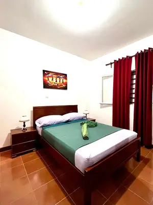 a bedroom with a bed with red curtains at Casa BB&Djassi - Apartment T1 in Ponta do Sol