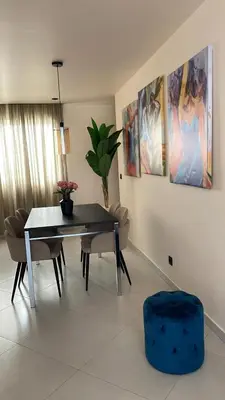 a dining room with a table and chairs and paintings at Apartamentos Esperança in Sal Rei
